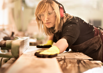 Handwerkerin schneidet Holz