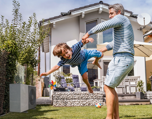 Vater spielt mit Kind im Garten