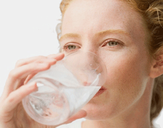 Frau trinkt ein Glas Wasser