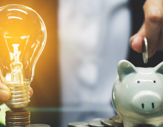 Leuchtende Glühbirne und Sparschwein