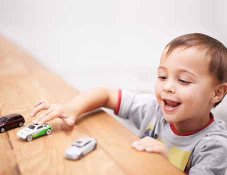 Kind mit Spielzeugautos