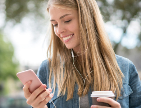Junge Frau schaut auf ihr Smartphone