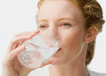 Frau trinkt aus Wasserglas