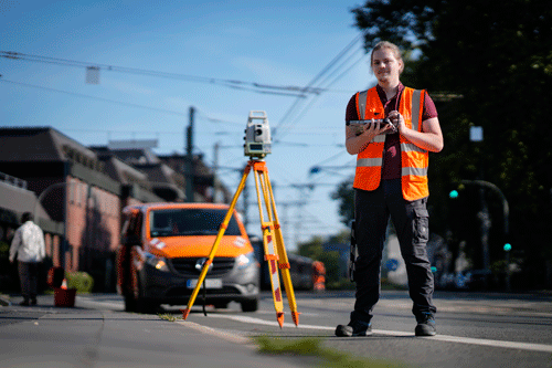 Ein Auszubildender führt Vermessungen auf der Straße durch
