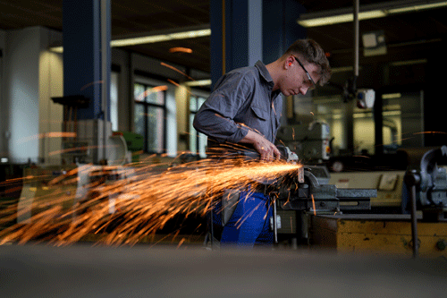 Ein Auszubildender verwendet einen Winkelschleifer