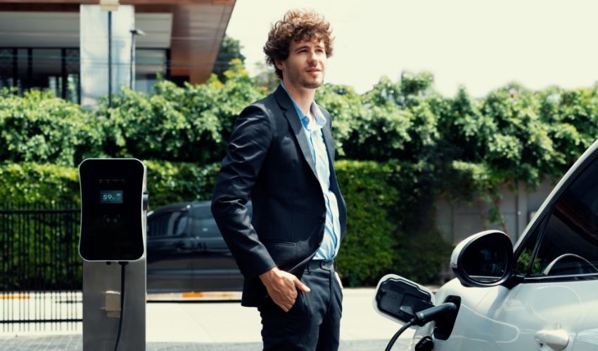 Mann lädt Elektroauto an Ladesäule