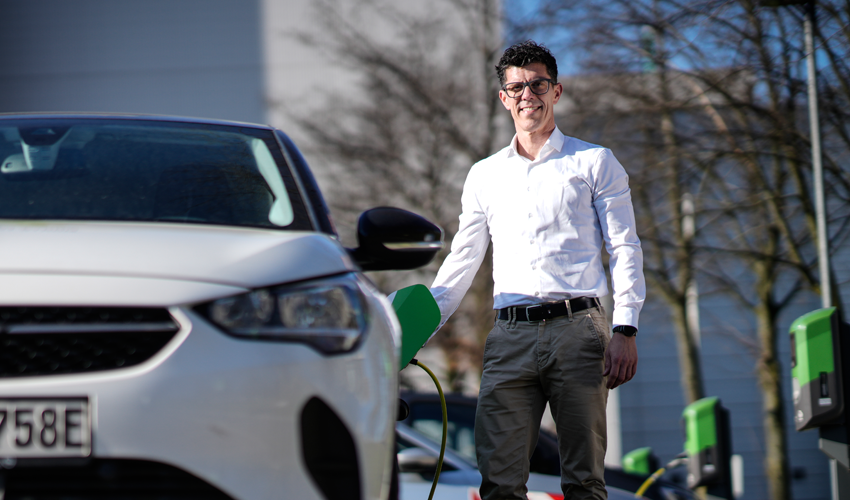 Mann lädt Elektroauto