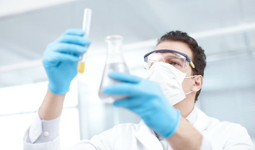 Laborant mit Reagenzglas und Wasserprobe