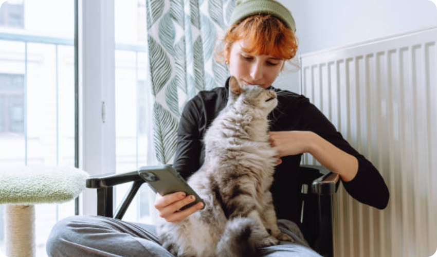Frau mit Katze vor Heizung